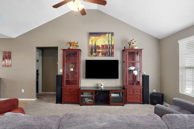 carpeted living area featuring baseboards, a ceiling fan, and vaulted ceiling