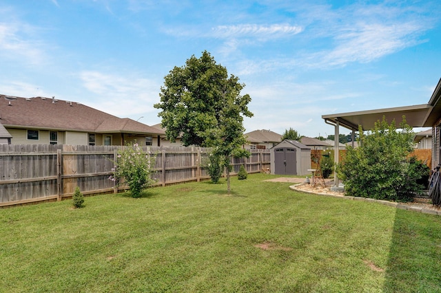 view of yard with an outdoor structure, a fenced backyard, and a shed