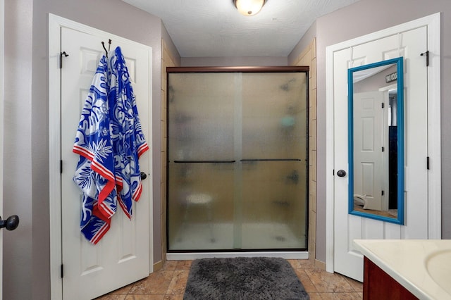 bathroom featuring vanity, stone finish floor, and a stall shower