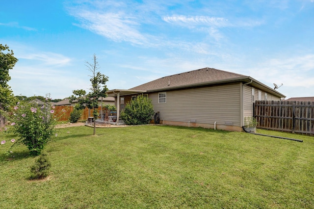 rear view of property with a lawn and fence