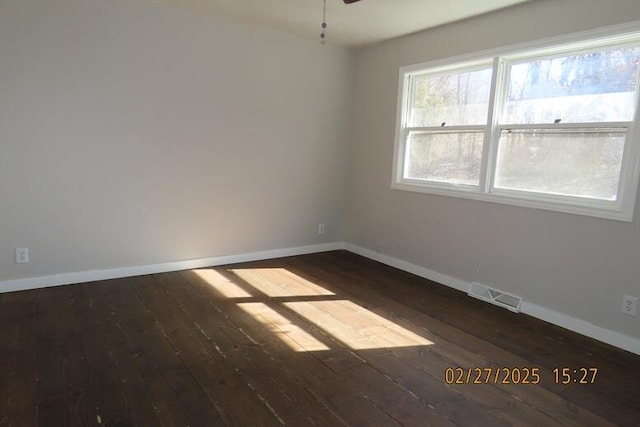 empty room with visible vents, ceiling fan, baseboards, and hardwood / wood-style floors