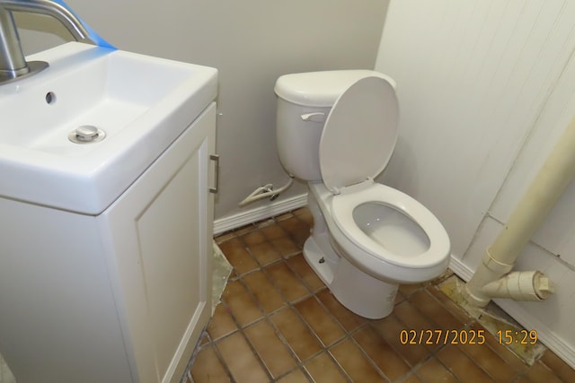 half bath featuring vanity, toilet, baseboards, and tile patterned flooring