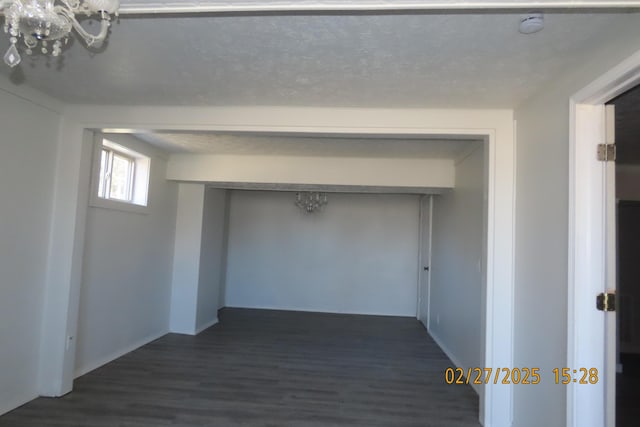 below grade area with dark wood-style floors and a textured ceiling