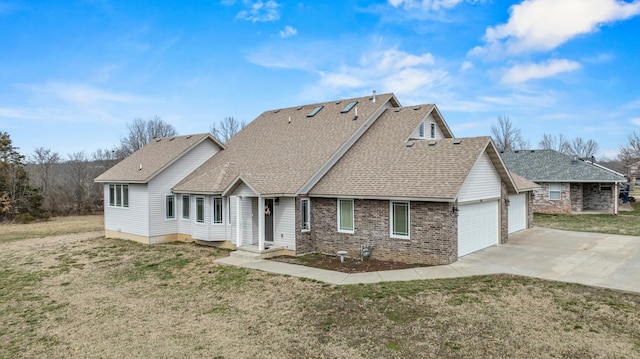 view of front of home featuring driveway, a front lawn, roof with shingles, an attached garage, and brick siding