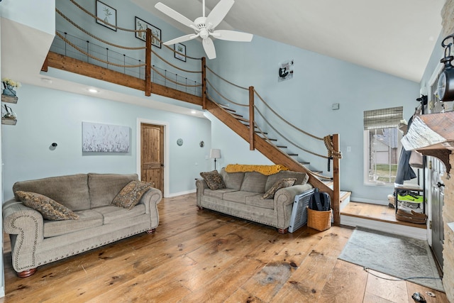 living area featuring ceiling fan, stairway, high vaulted ceiling, and hardwood / wood-style floors