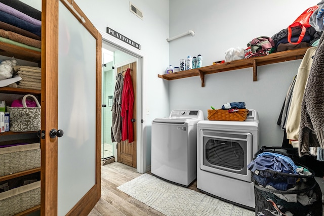 clothes washing area featuring laundry area, light wood-style flooring, visible vents, and independent washer and dryer