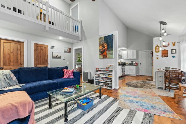 living room featuring high vaulted ceiling and wood finished floors