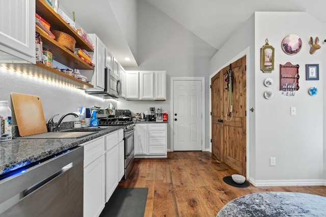 kitchen with vaulted ceiling, stainless steel appliances, dark wood-style floors, white cabinetry, and open shelves