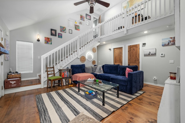 living area featuring ceiling fan, stairway, high vaulted ceiling, and wood finished floors