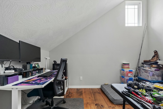 office area with lofted ceiling, wood finished floors, baseboards, and a textured ceiling