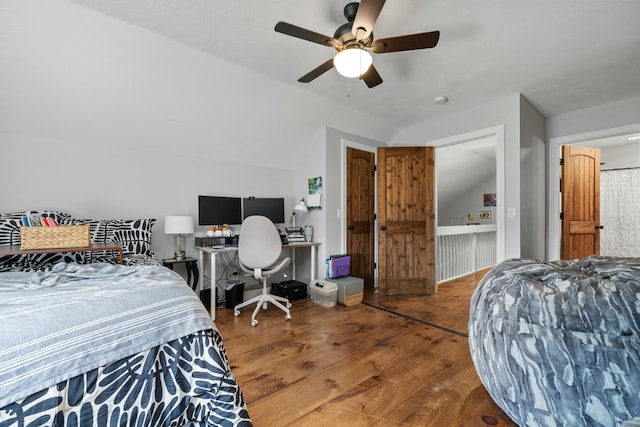 bedroom with ceiling fan, lofted ceiling, and wood finished floors