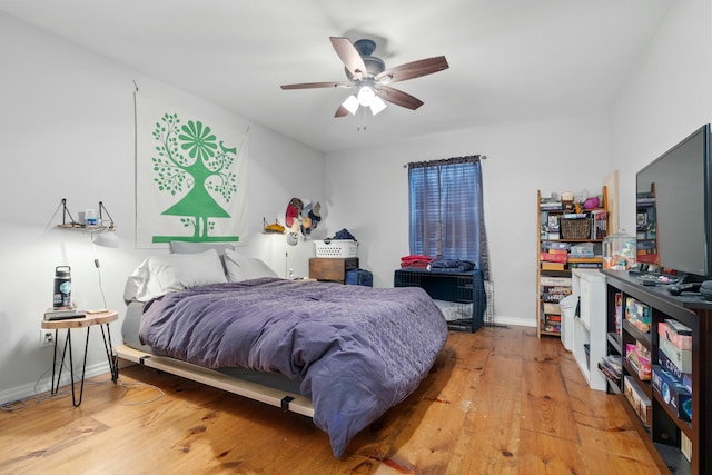 bedroom featuring light wood finished floors, ceiling fan, and baseboards