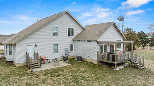 back of house featuring a patio area, a lawn, a shingled roof, and central AC