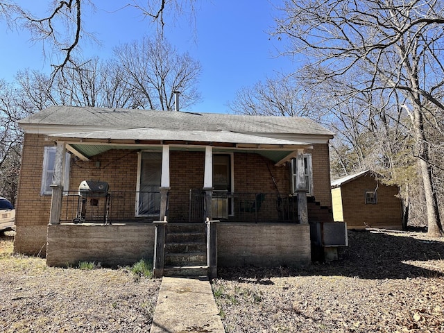 bungalow-style house featuring brick siding and covered porch