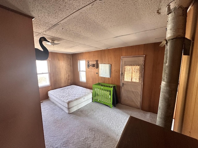 unfurnished bedroom featuring carpet and wood walls