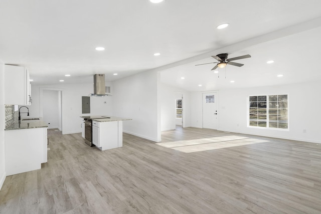 kitchen featuring a sink, exhaust hood, light wood-style floors, and electric range oven