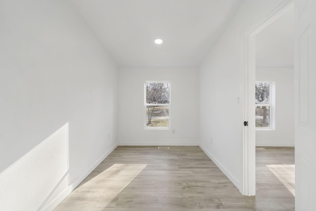 empty room featuring recessed lighting, baseboards, and light wood-style floors