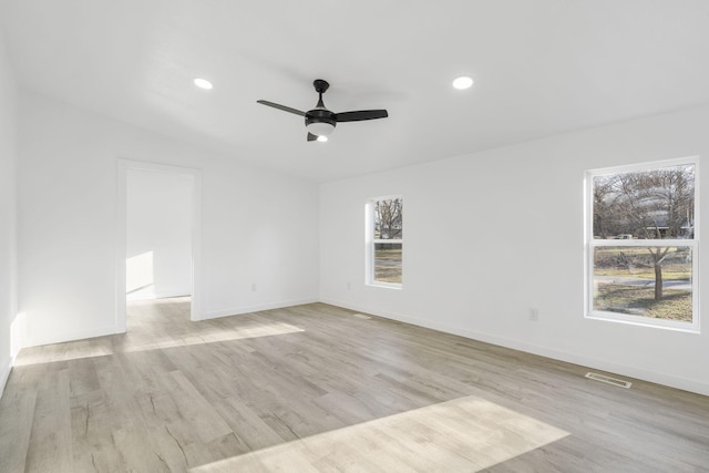 spare room featuring a wealth of natural light, visible vents, wood finished floors, and recessed lighting