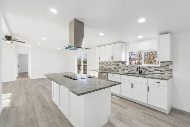 kitchen featuring a sink, a kitchen island, ventilation hood, black electric stovetop, and stainless steel dishwasher