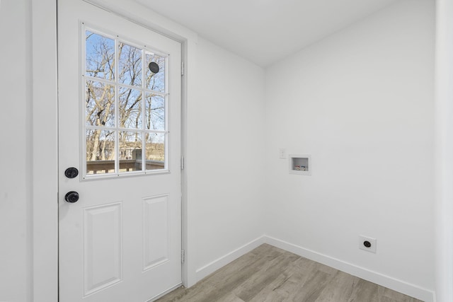 doorway featuring baseboards and light wood-type flooring