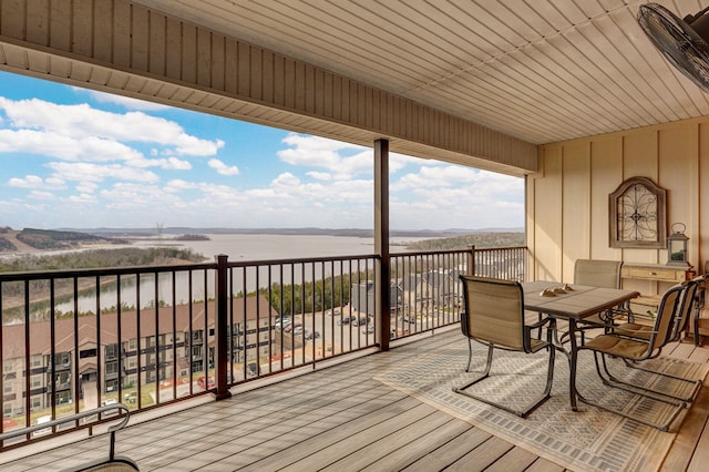 wooden terrace featuring outdoor dining area and a water view