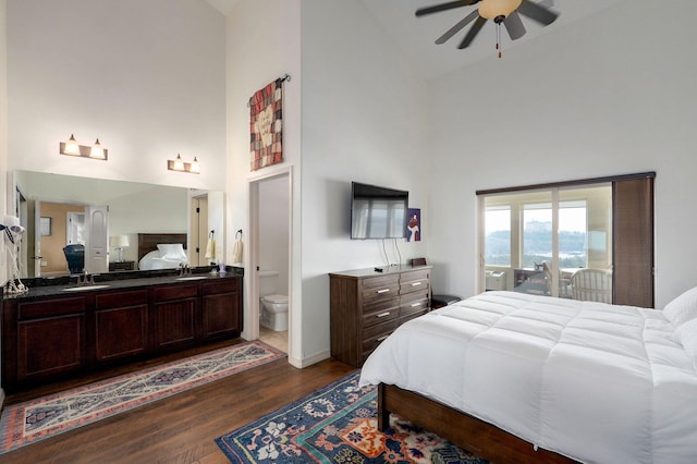 bedroom with a sink, high vaulted ceiling, access to exterior, and dark wood-style flooring