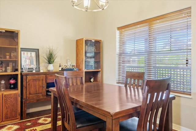 dining space featuring baseboards and a chandelier