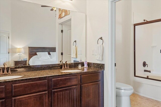 bathroom with shower / bathing tub combination, ceiling fan, a sink, and double vanity