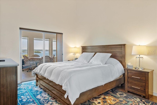 bedroom with a water view and access to outside