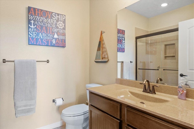 bathroom featuring a shower stall, toilet, and vanity