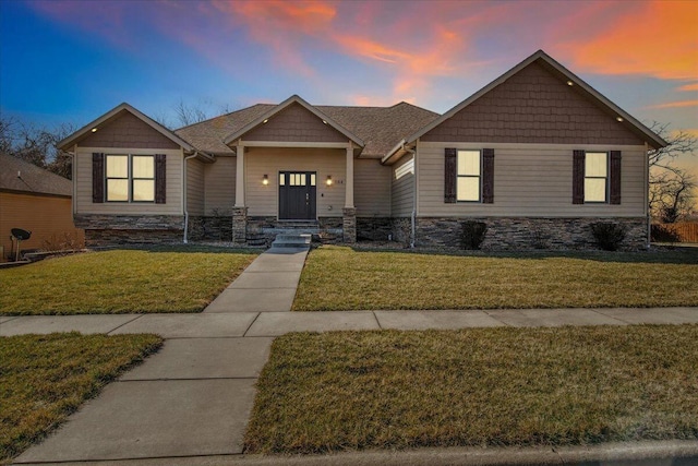 craftsman inspired home with roof with shingles and a front yard