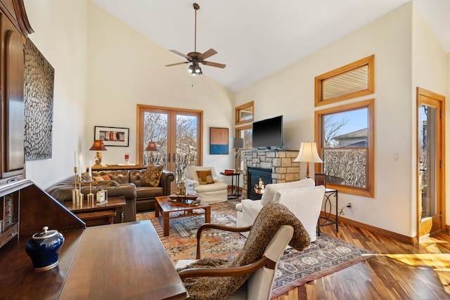 living room featuring hardwood / wood-style floors, baseboards, high vaulted ceiling, a fireplace, and french doors