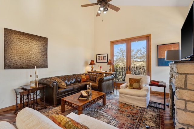 living room with french doors, baseboards, a high ceiling, and wood finished floors