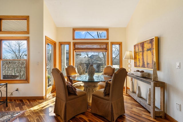 dining area with lofted ceiling, baseboards, and hardwood / wood-style floors