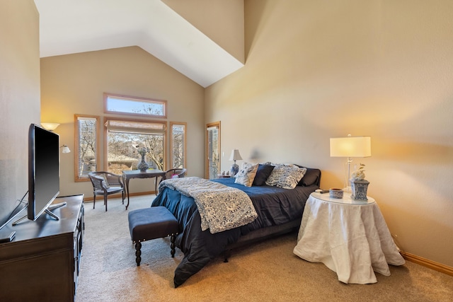 carpeted bedroom featuring baseboards and high vaulted ceiling