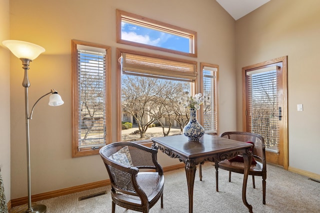 dining room featuring light carpet, visible vents, a healthy amount of sunlight, and baseboards