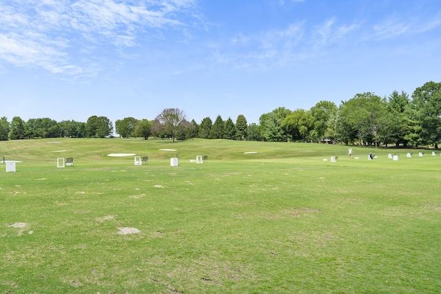 view of community with a yard and view of golf course