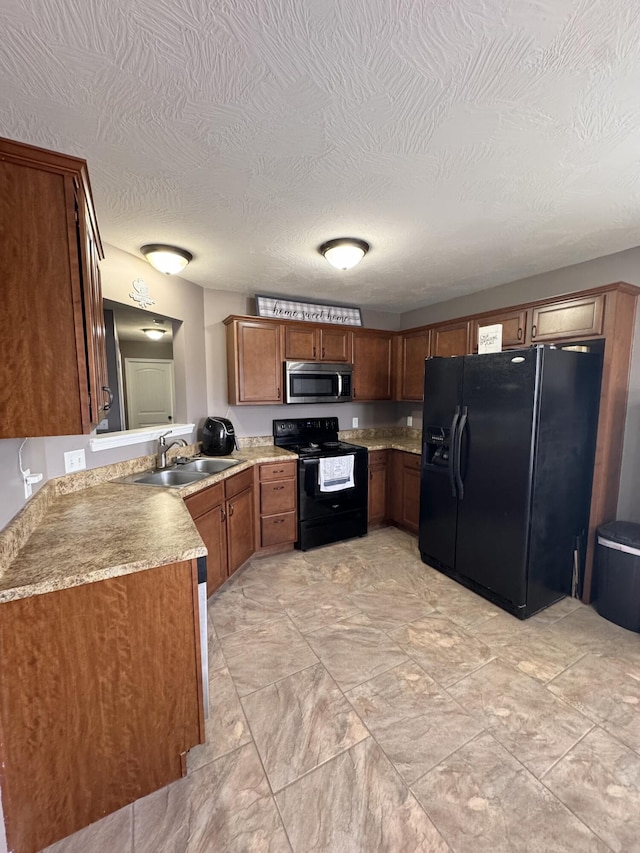 kitchen featuring black appliances, a sink, a textured ceiling, brown cabinetry, and light countertops