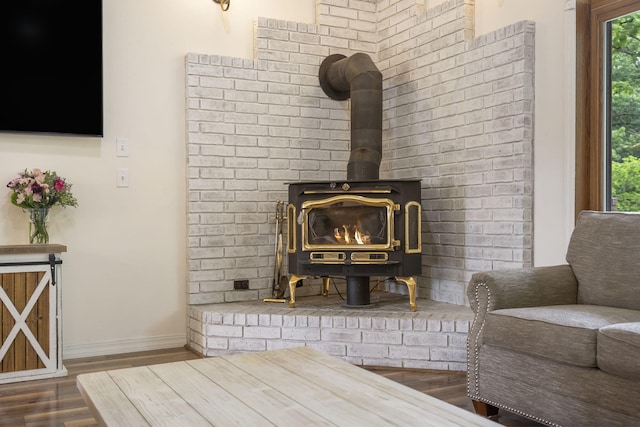 interior details featuring a wood stove, baseboards, and wood finished floors