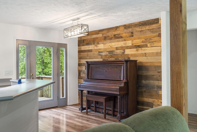 sitting room with a textured ceiling, an inviting chandelier, and wood finished floors