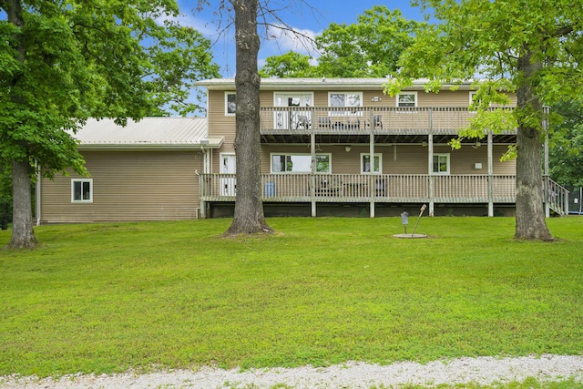 rear view of house with a wooden deck, a lawn, and metal roof