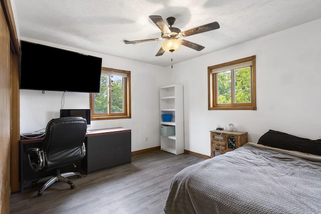 bedroom with ceiling fan, baseboards, light wood-type flooring, and a textured ceiling