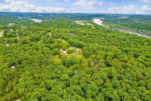 drone / aerial view with a forest view and a water view