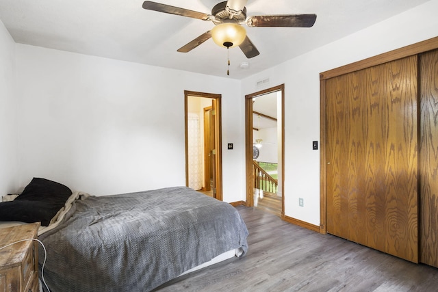 bedroom with visible vents, baseboards, wood finished floors, and a ceiling fan