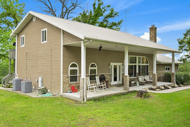 back of house with a lawn, central AC unit, outdoor lounge area, and a patio area