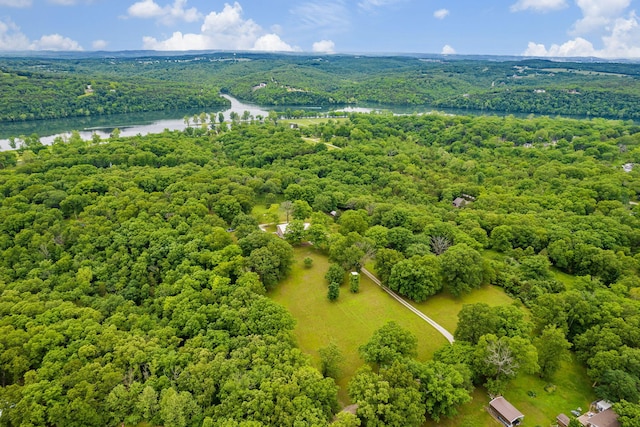 drone / aerial view featuring a wooded view and a water view