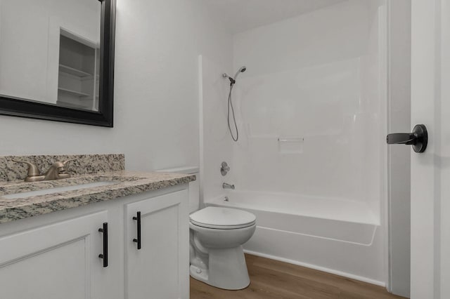 bathroom with vanity, bathing tub / shower combination, toilet, and wood finished floors