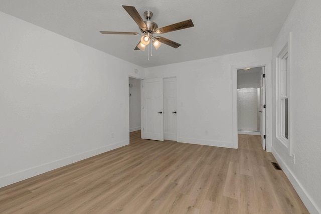 unfurnished bedroom featuring visible vents, baseboards, a ceiling fan, and light wood finished floors