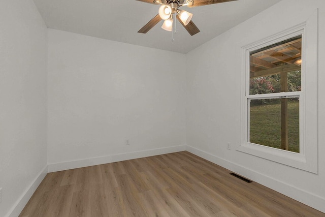 spare room featuring light wood-type flooring, baseboards, visible vents, and ceiling fan