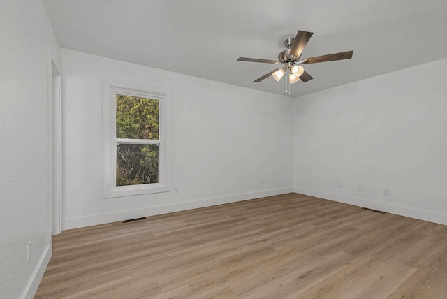 spare room with visible vents, baseboards, a ceiling fan, and light wood finished floors